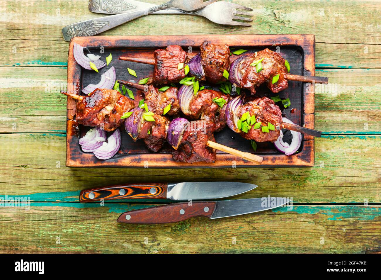 Grilled liver kebab with onion on wooden skewers.Tasty kebab on wooden