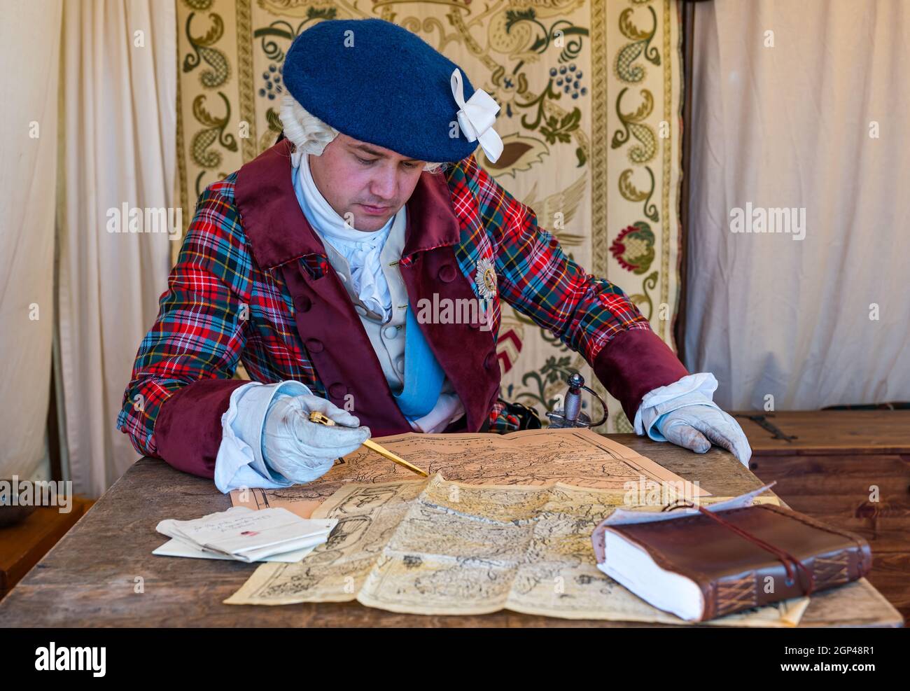 Dr Arran Johnstone as Bonnie Prince Charlie in period costume studies old maps in re-enactment of Battle of Prestonpans, East Lothian, Scotland, UK Stock Photo