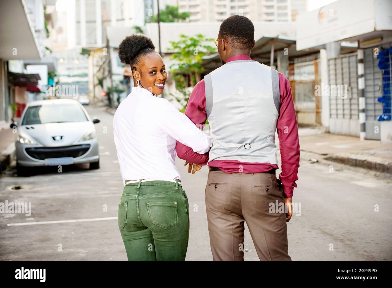 rear view of a young couple holding hands and walking back in the ...