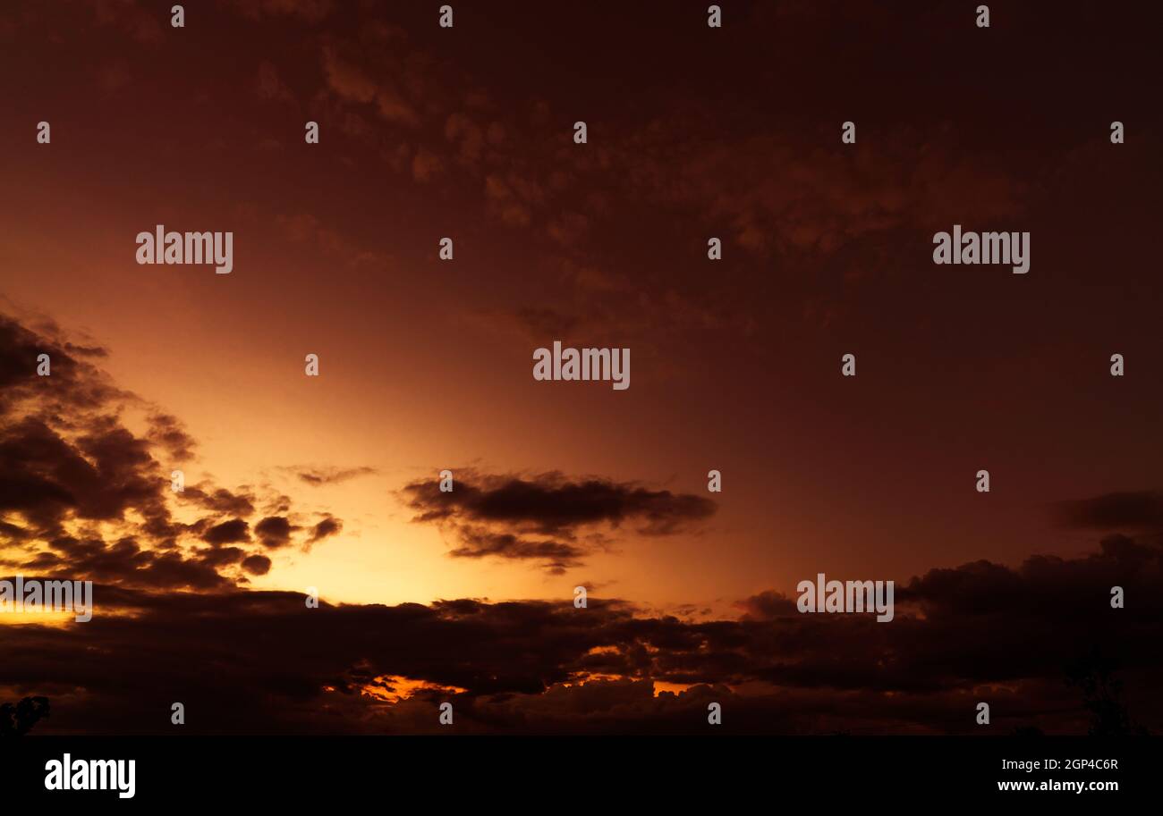 Orange and golden sunset sky with dark clouds. Beauty in nature ...