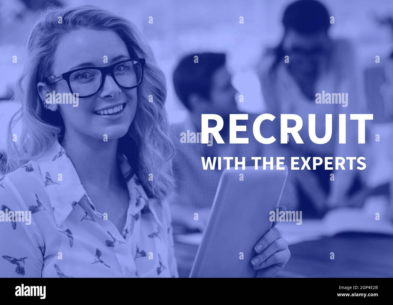 Composition of recruit with the experts text over smiling business people using tablet Stock Photo