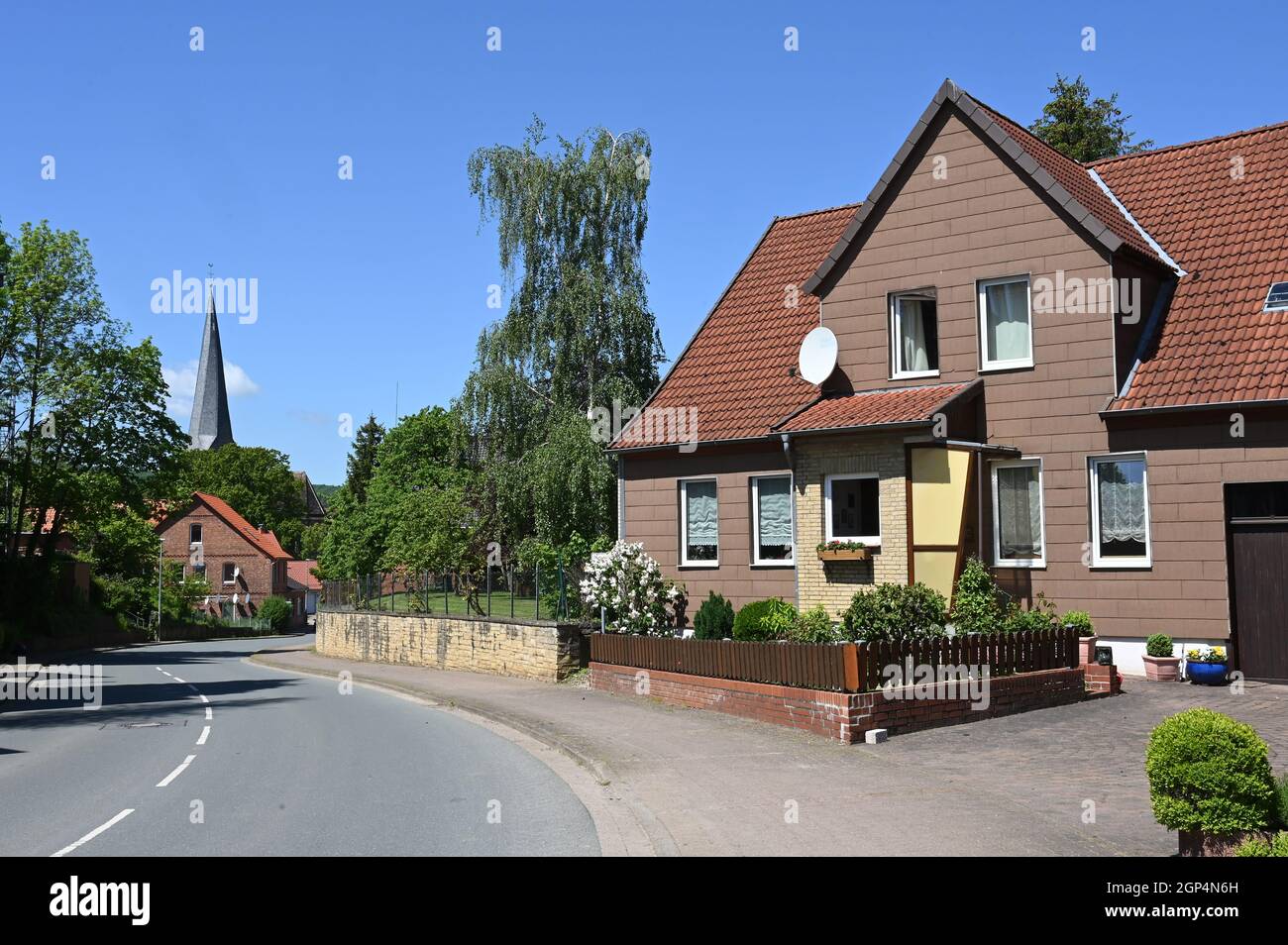 Village street in Beber with a view of the steeple of St. Magnus Church Stock Photo