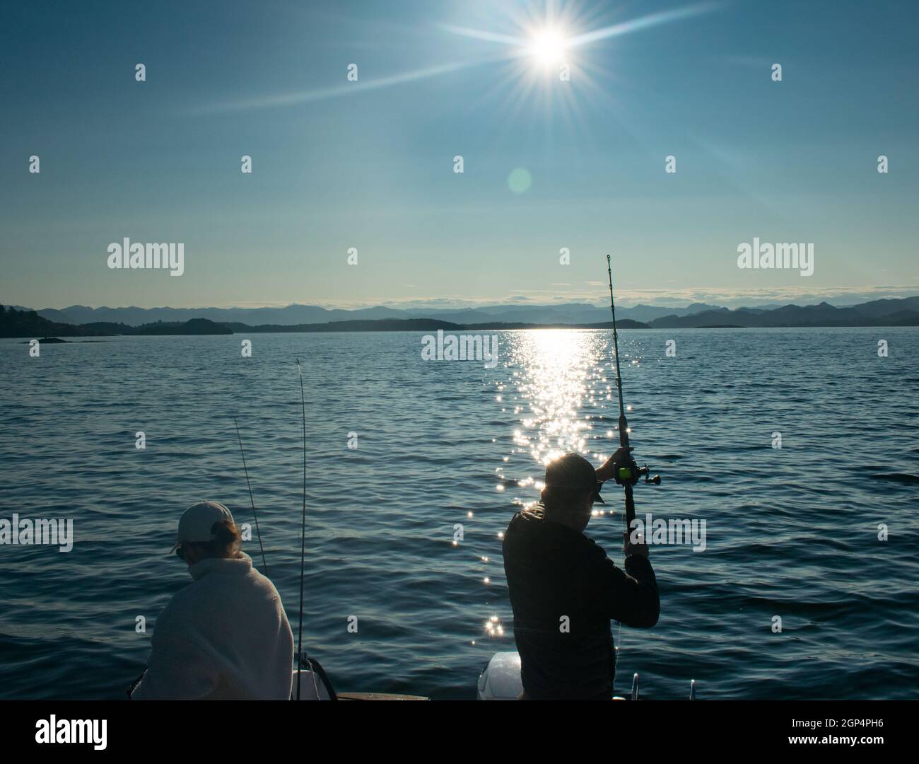 Couple with fishing rod on a boat in the ocean near Stavanger Norway (jig fishing) Stock Photo