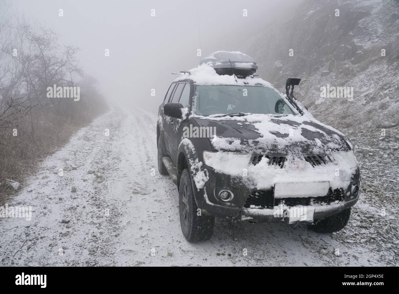 SUV on the rise of snow winter forest Stock Photo