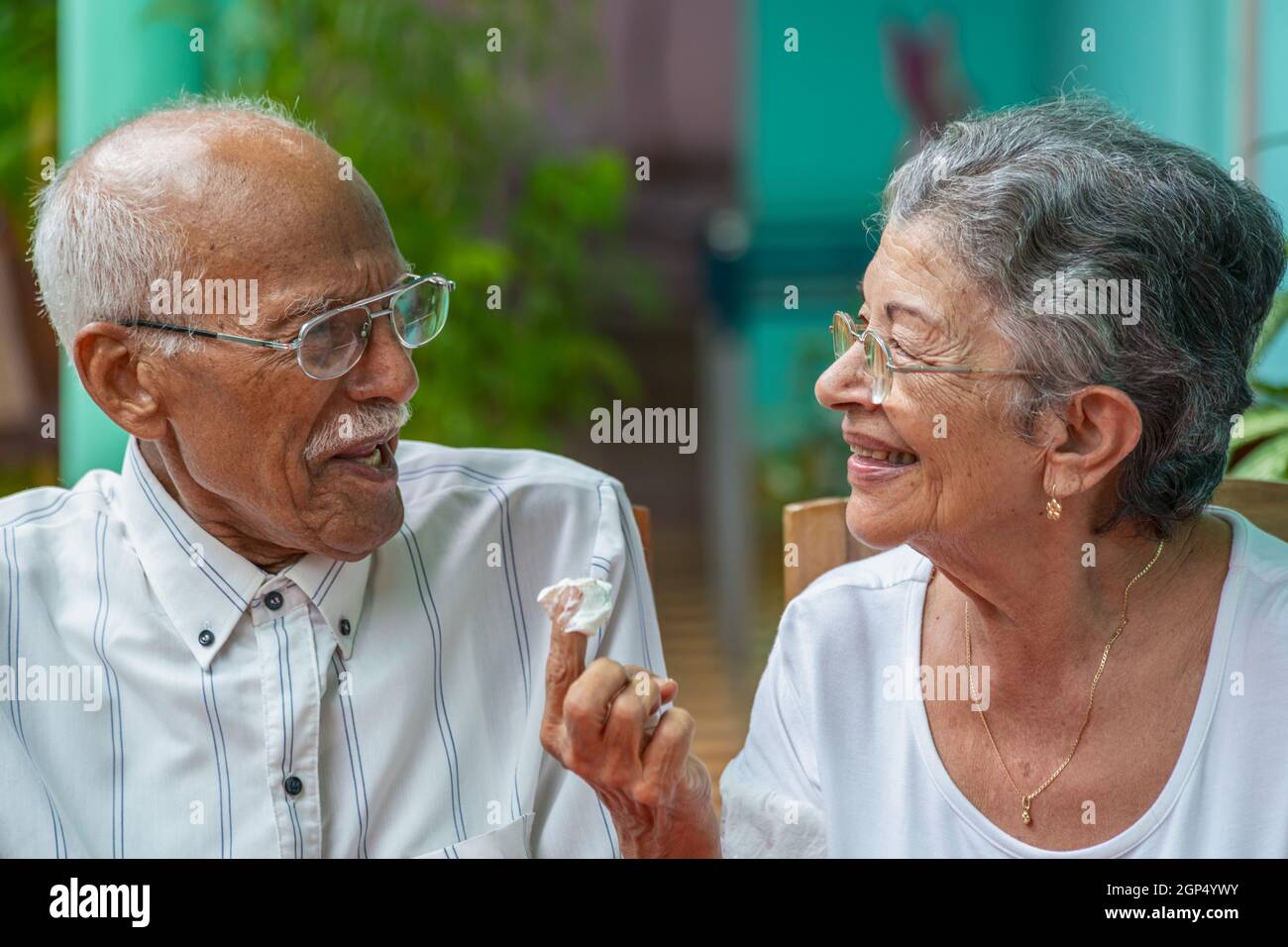 Elderly couple looking at each other smilingly and the woman with a ...