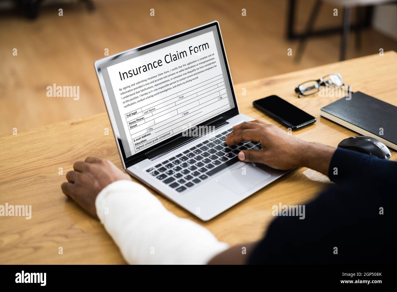 Broken Arm Injured Worker Compensation Coverage. Using Office Laptop Stock Photo
