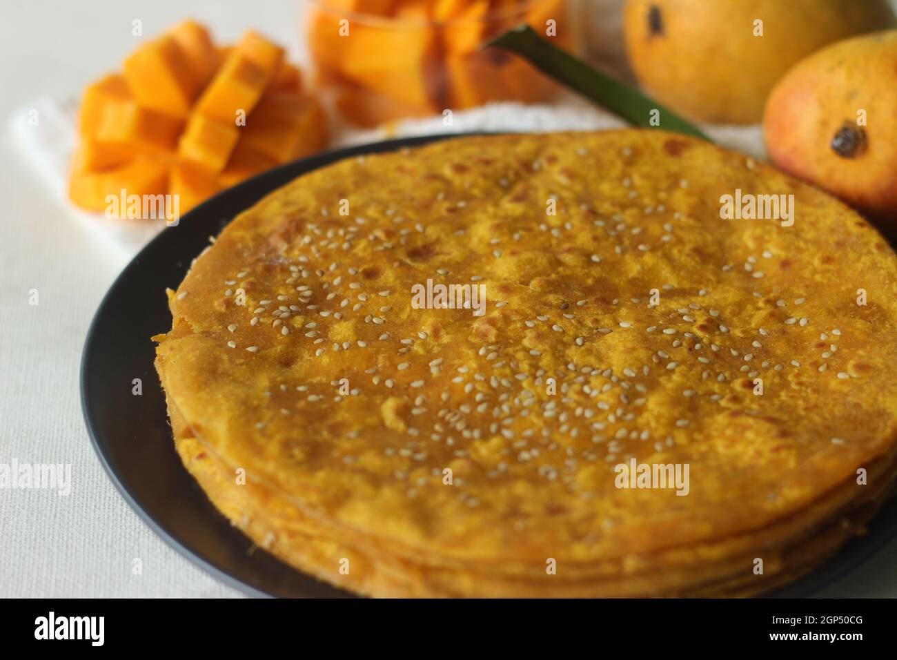 Mango Paratha. Indian flatbread made of wheat flour and mango pulp. A sweet version of Indian flatbread with fresh mangoes topped with sesame seeds. S Stock Photo
