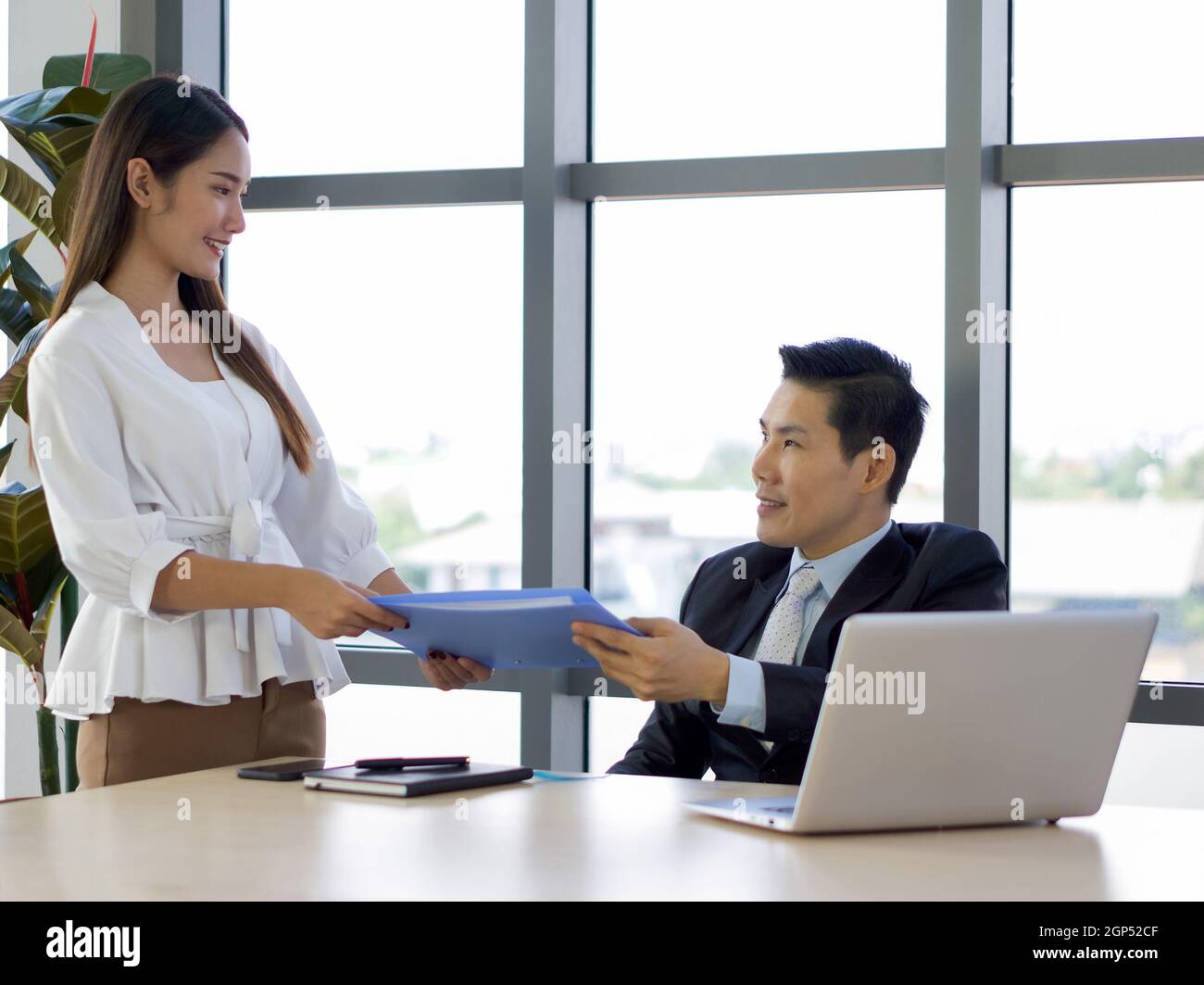 Managing Director in suit returns document folder to secretary with an ...