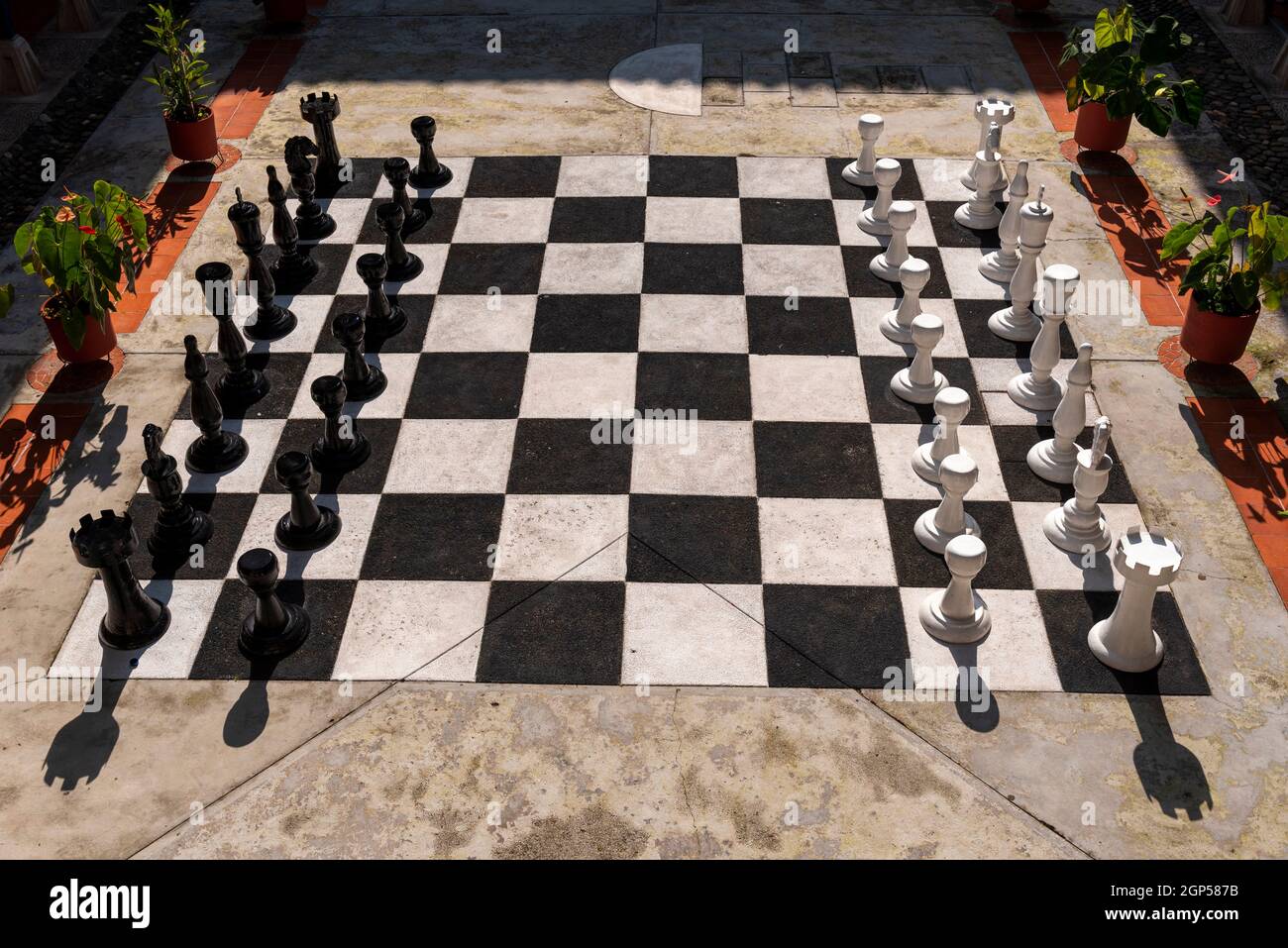 A large life size knight chess pieces on a large chess board, outside on a bright sunny day Stock Photo