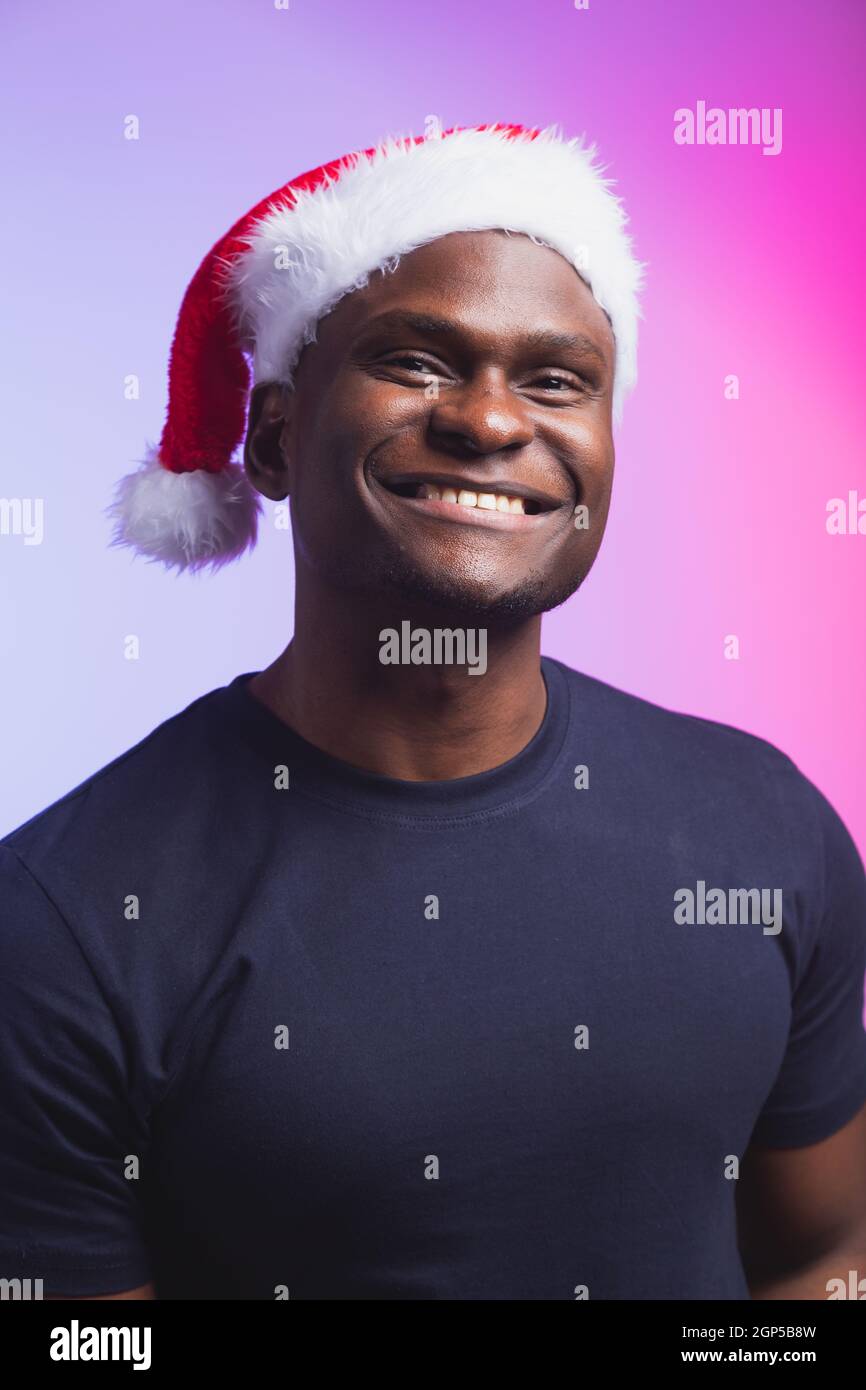 Portrait of positive handsome man in santa hat and casual t-shirt on ...