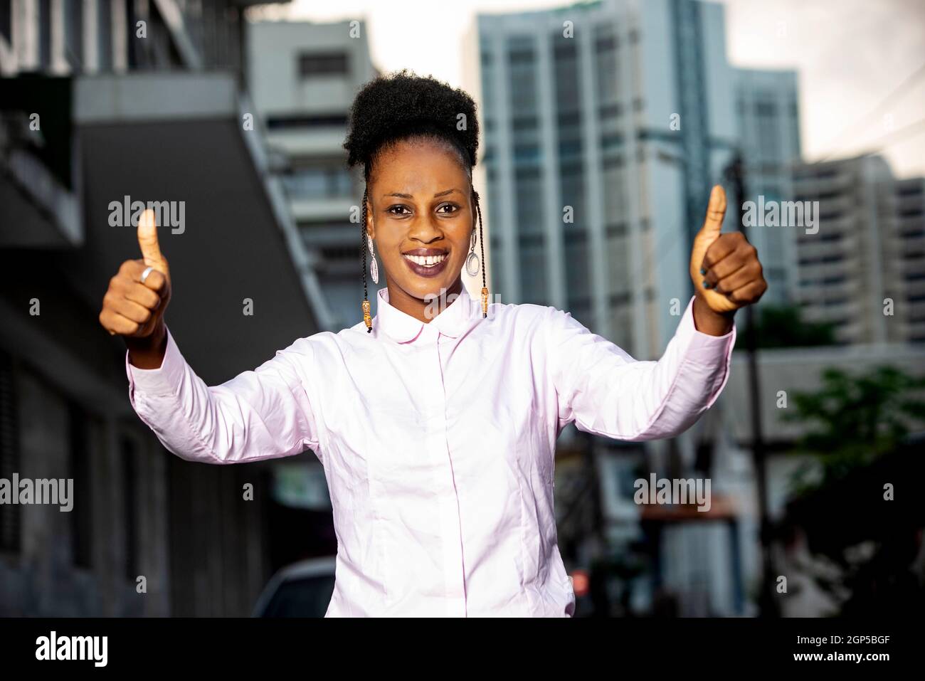 young african woman standing outdoors smiling to lift thumbs up Stock ...