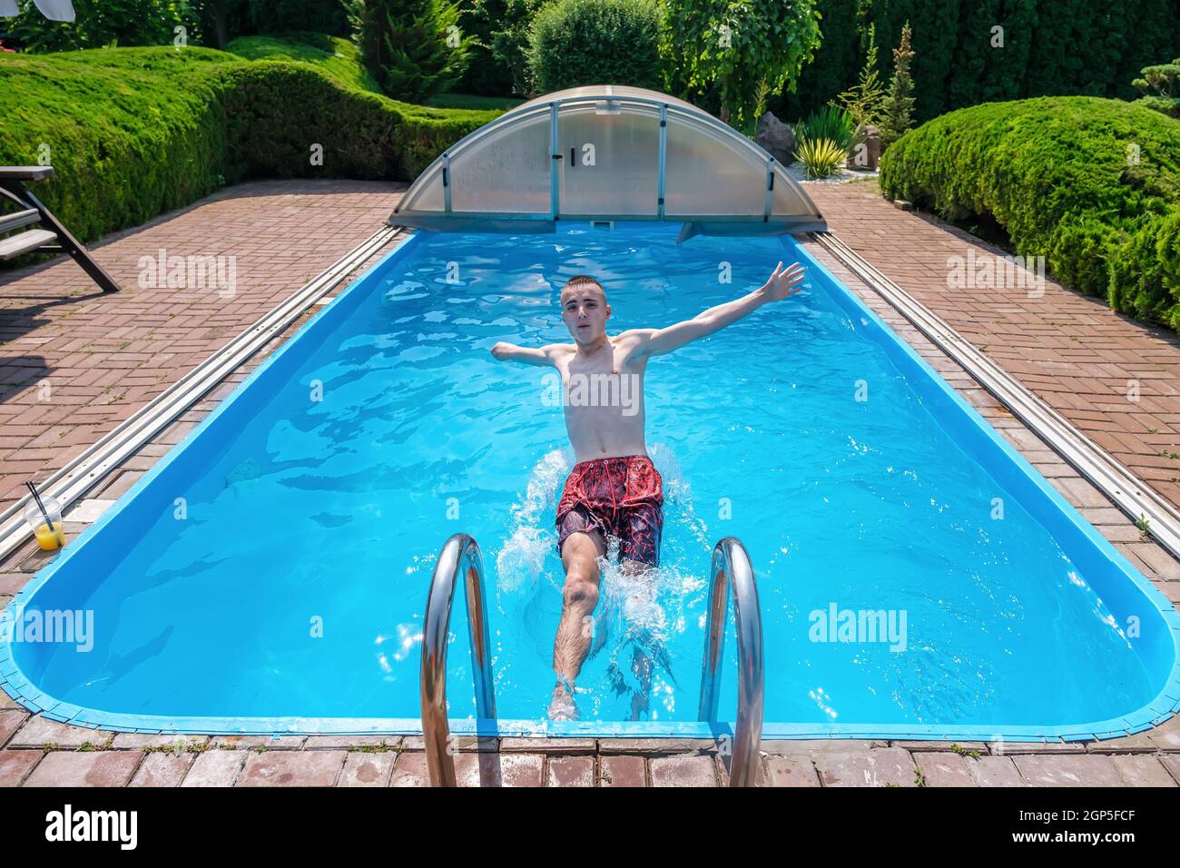 Disabled man jumping in swimming pool Stock Photo