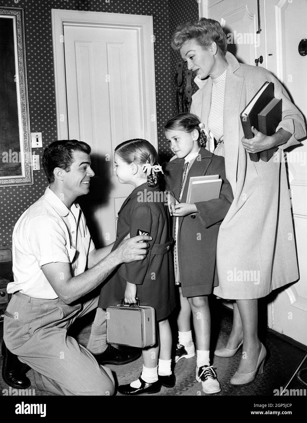From left: Brooks West says goodbye to daughters Connie West, Liza West, and wife Eve Arden, as they head to school, 1953 Stock Photo