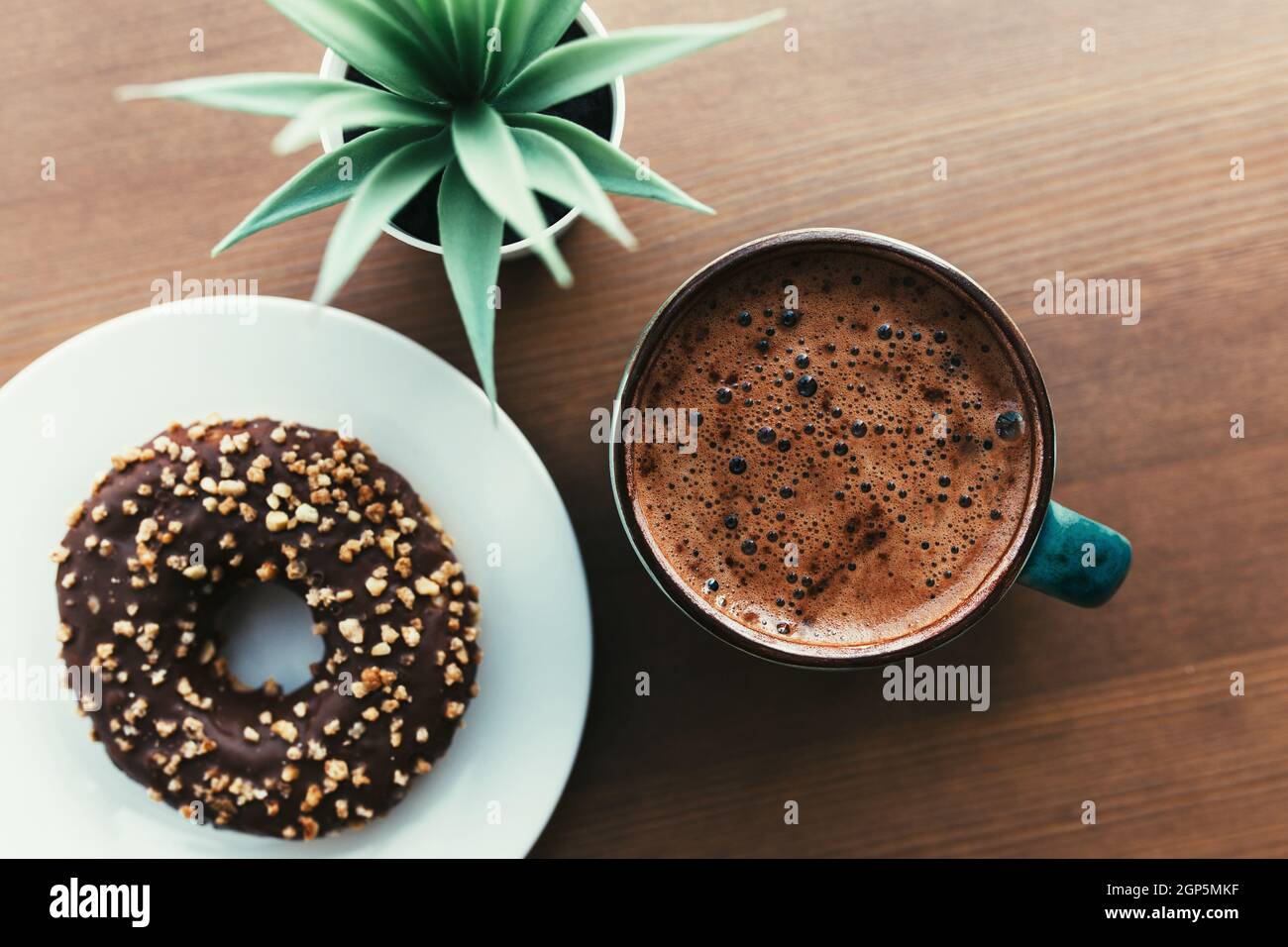 Donuts on the white plate, coffee and green plant on the wooden table. High  quality photo Stock Photo - Alamy