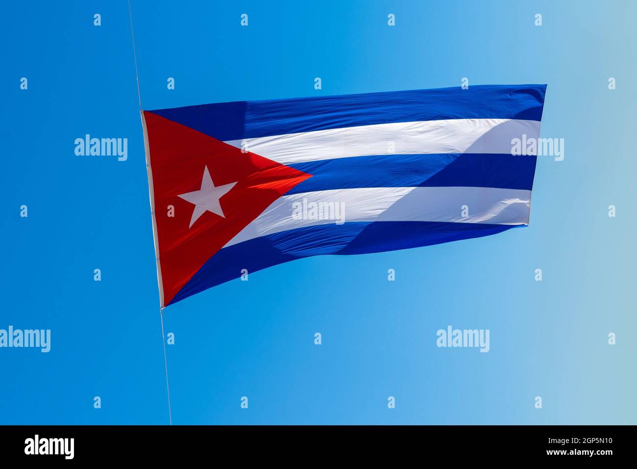 fattige skab dråbe A Cuban flag with three blue an two white stripes, and a red triangle with  a white star. Blue background Stock Photo - Alamy