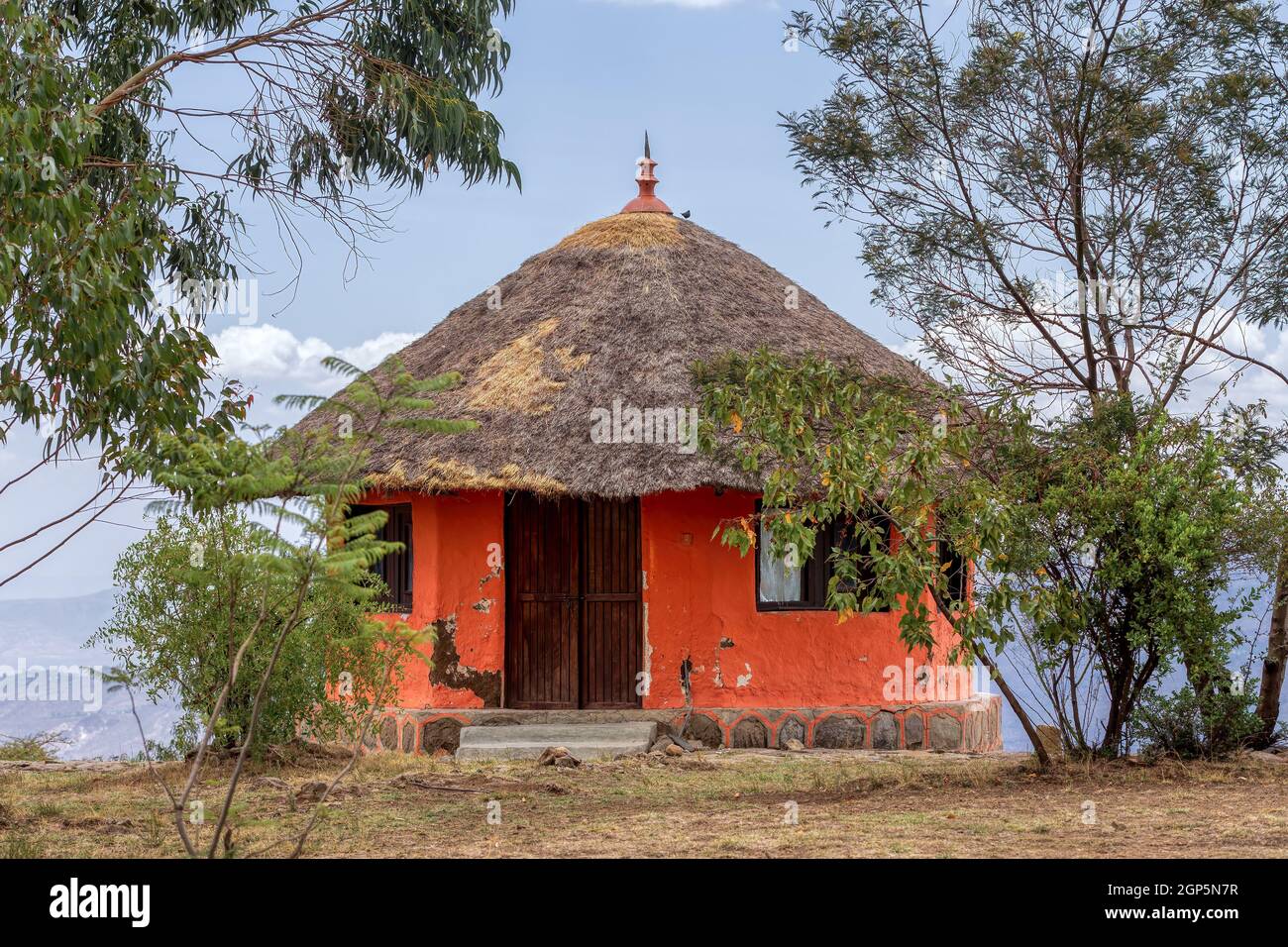 Beautiful colored traditional ethiopian house situated in mountain landscape with scenic view to canyon. Debre Libanos, Ethiopia, Africa. Stock Photo