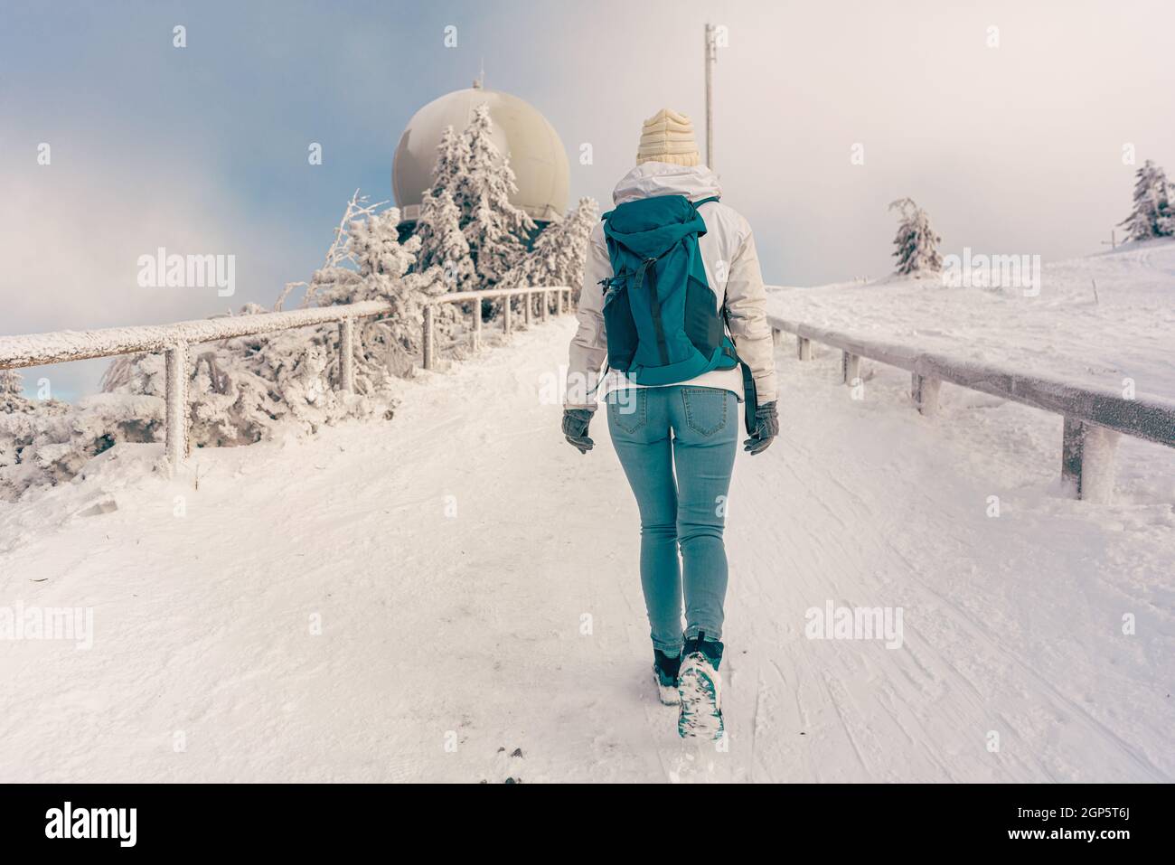 Winter hike at the peak of the Grosser Arber mountain with woman walking up a path Stock Photo