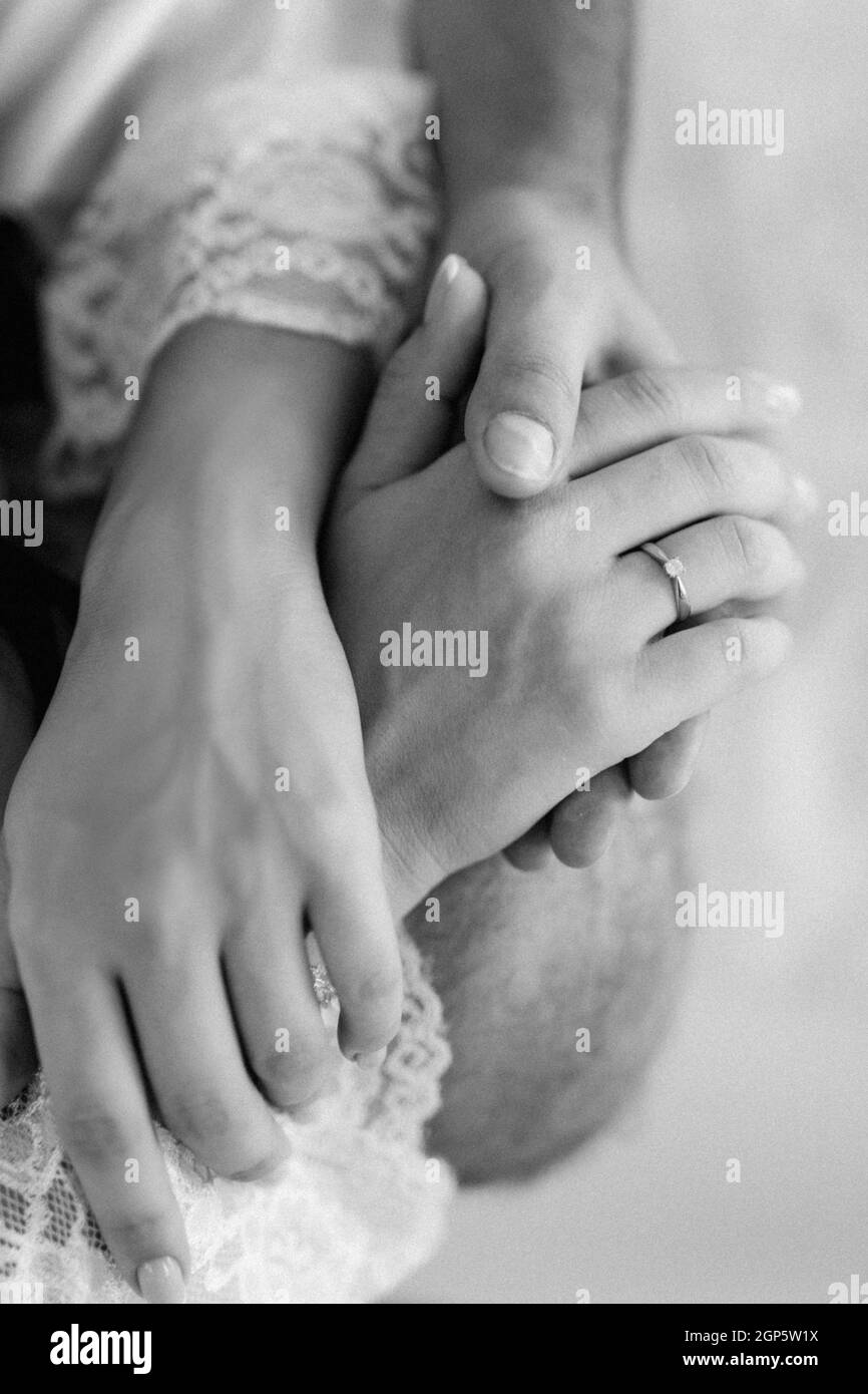 the bride and groom tenderly hold hands between them love and relationships Stock Photo