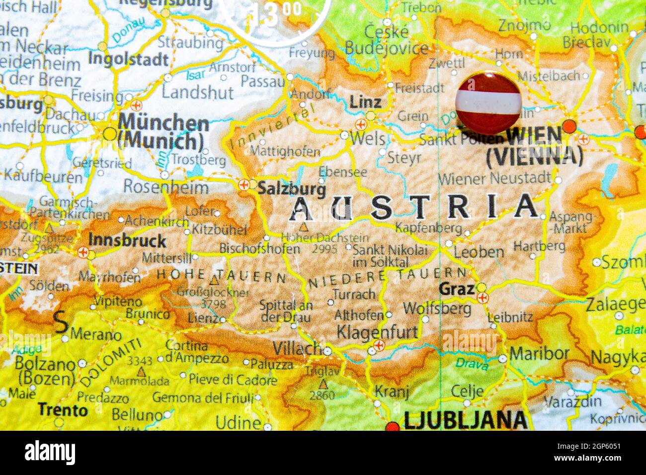 Austria national flag pinned on Europe map. Macro Close up picture of country on a colorful and Blurry World Map Globe with focus to capital Vienna. P Stock Photo