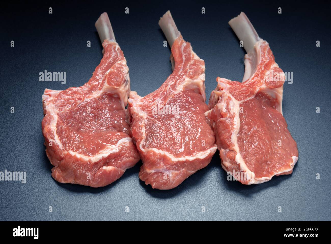 raw lamb saddle meat on bone top view on black background Stock Photo