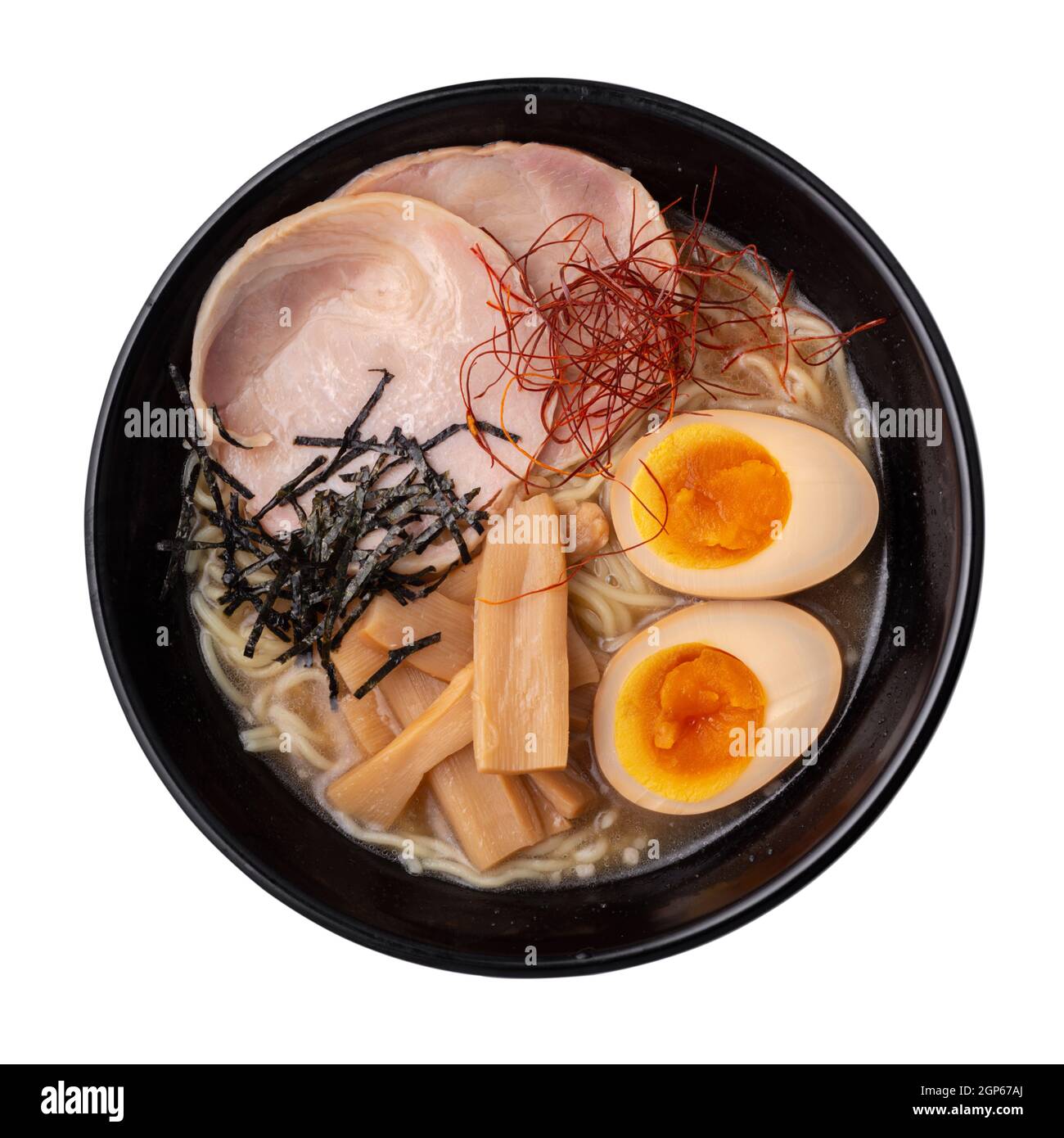 Asian ramen noodles soup with egg, pork and bamboo shoots in bowl is isolated on white background, Japanese cuisine Stock Photo
