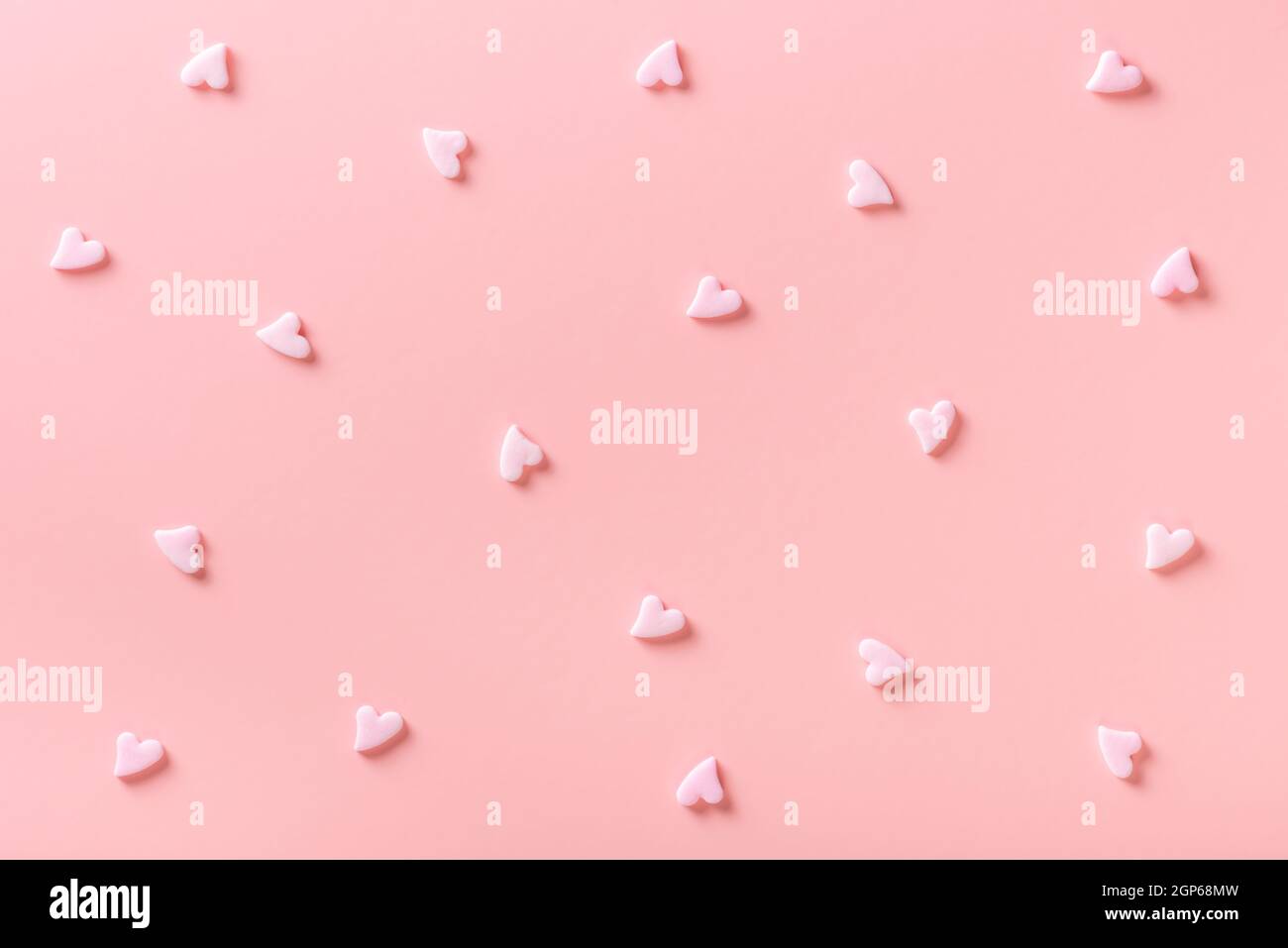 sweet sprinkles of heart shapes over pink background, concept of festive invitation for Valentines day, birthday, holiday and party time Stock Photo