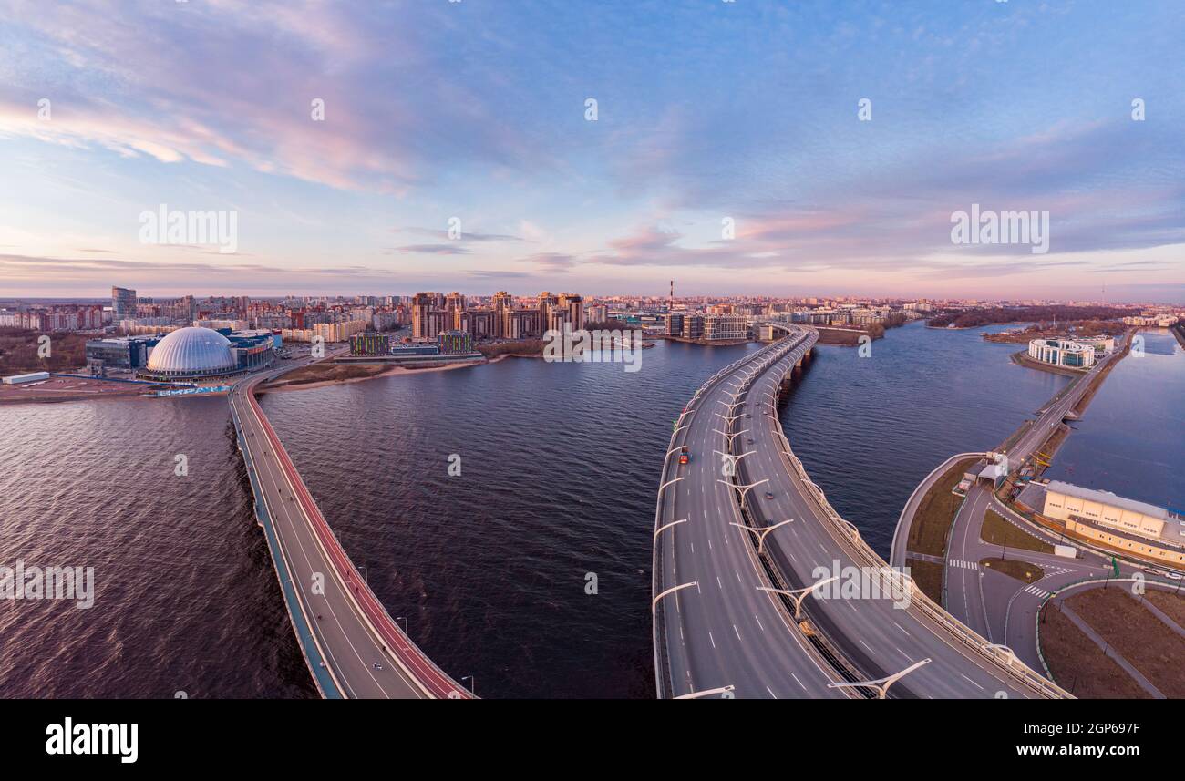 Aerial Panoramic view to evening St. Petersburg and Cable-stayed bridge across Petrovsky fairway. Western high-speed diameter WHSD at sunset. Modern h Stock Photo