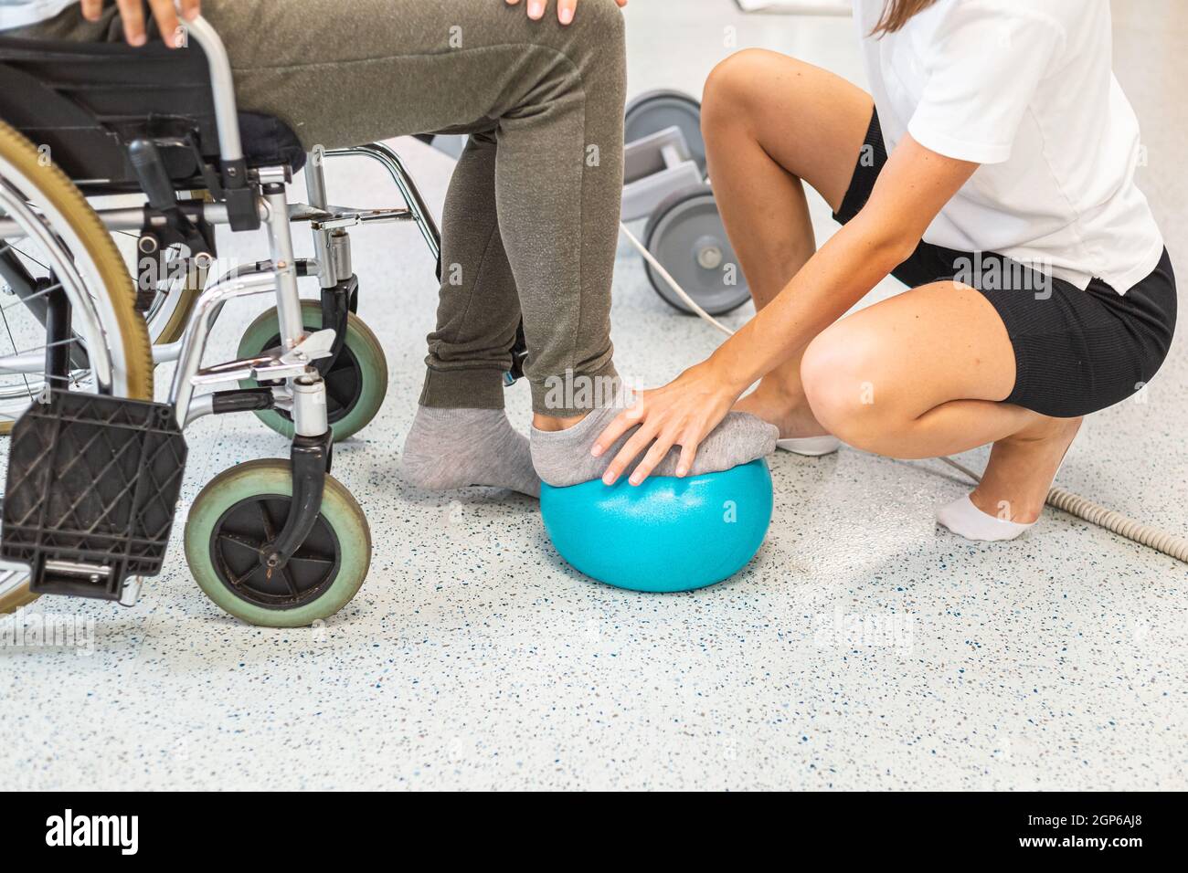 Pphysiotherapist and male patient seated in a wheelchair during