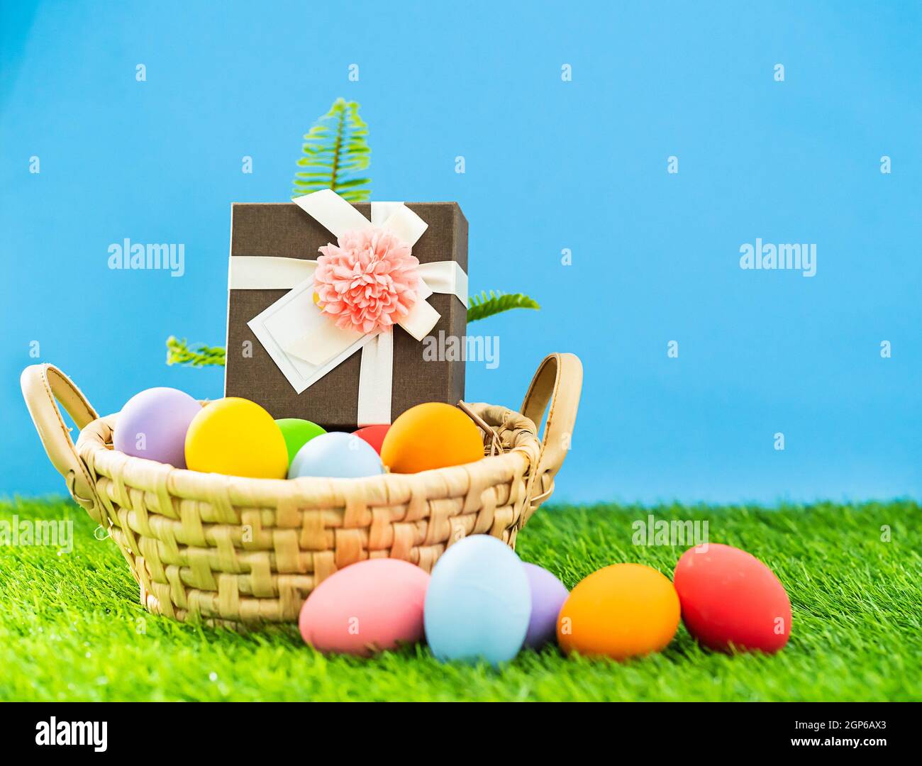Colorful easter eggs in the basket on green grass background with copy ...