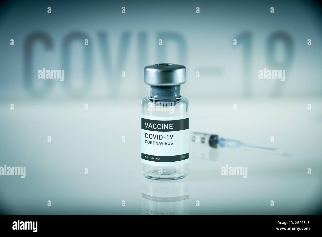 Covid-19 vaccine bottle and syringe on a blue laboratory background ...