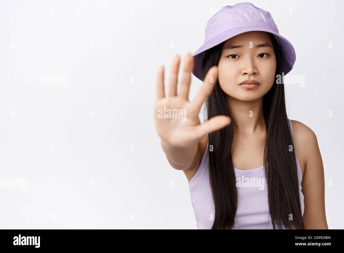 Serious asian girl extend one hand, showing stop gesture, saying