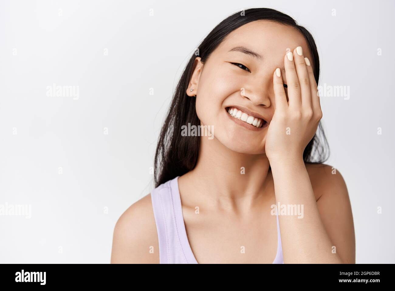 Beauty and skin care. Attractive asian girl touching face and smiling ...
