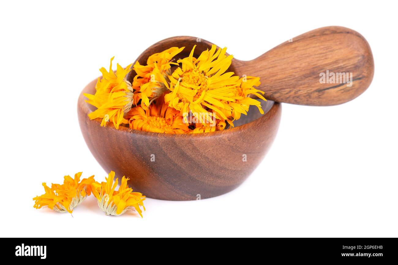 Dried calendula flowers in wooden bowl and spoon, isolated on white ...