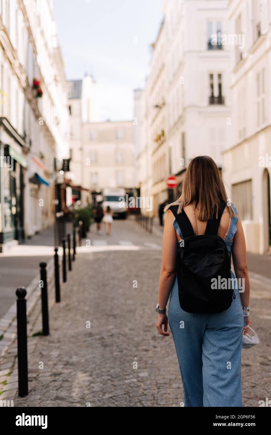 Tourist with a backpack walking by the streets of Paris, France Stock