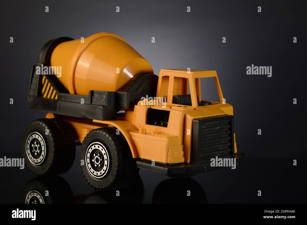 A toy cement mixer over a dark gradient background. Stock Photo