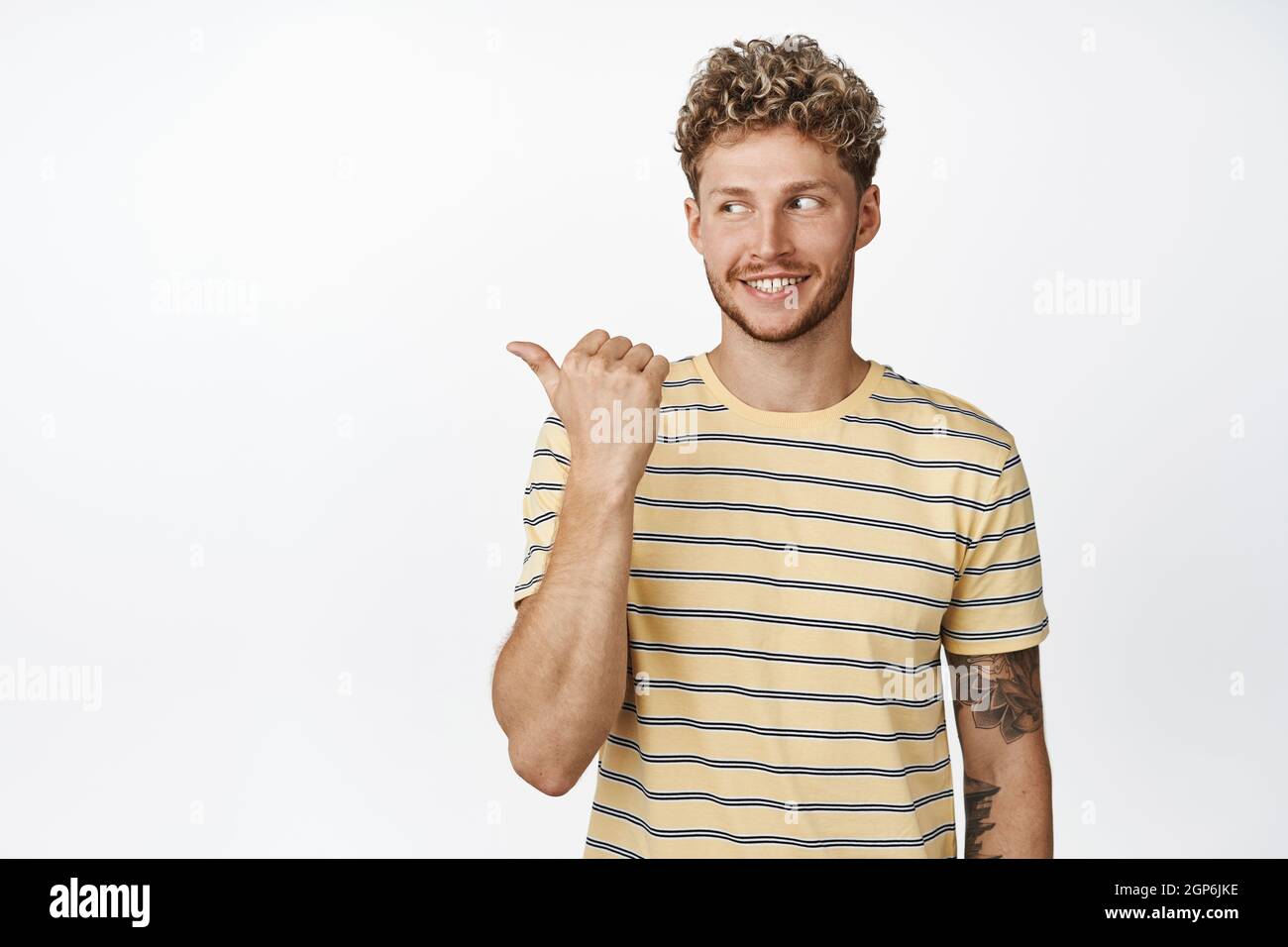 Excited smiling caucasian man pointing, looking left at logo with ...