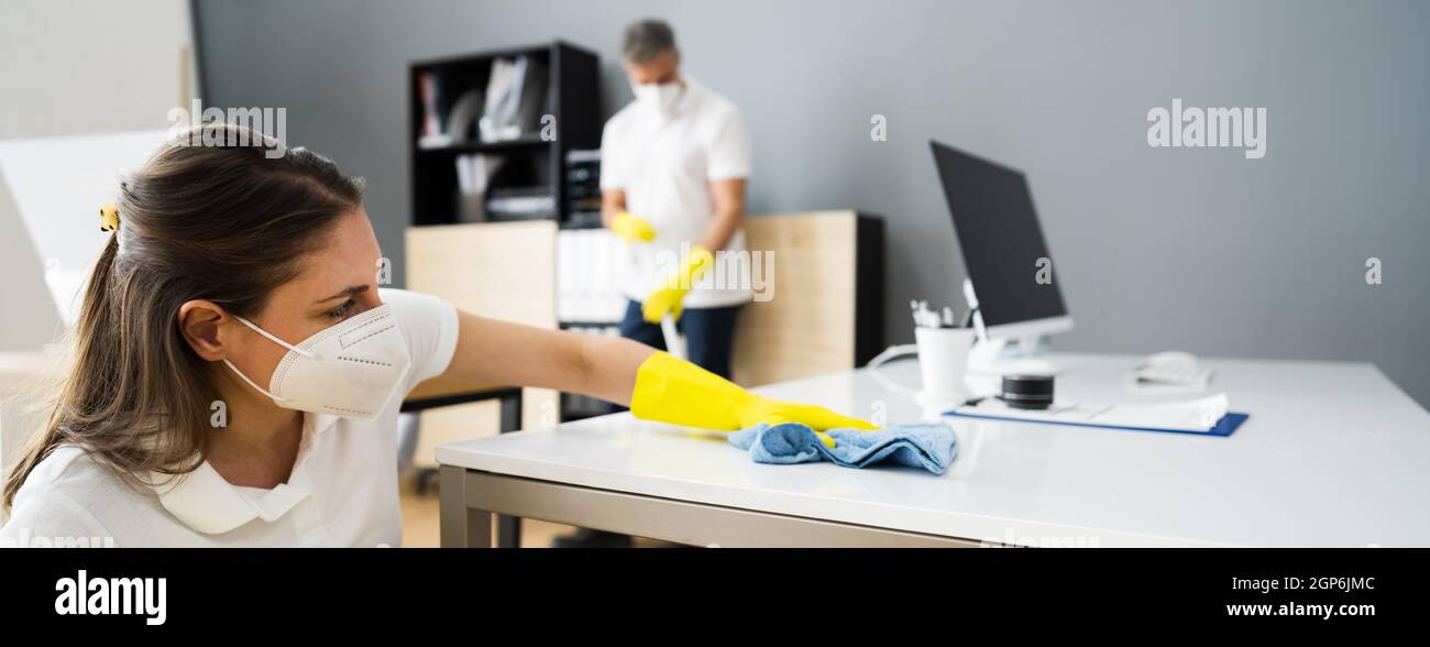 Janitor Cleaner Woman In Face Mask Cleaning Desk Stock Photo