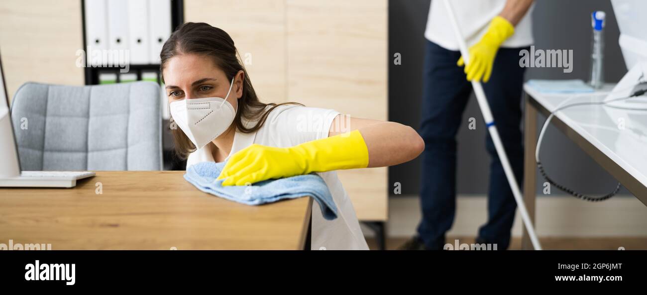 Janitor Cleaner Woman In Face Mask Cleaning Desk Stock Photo
