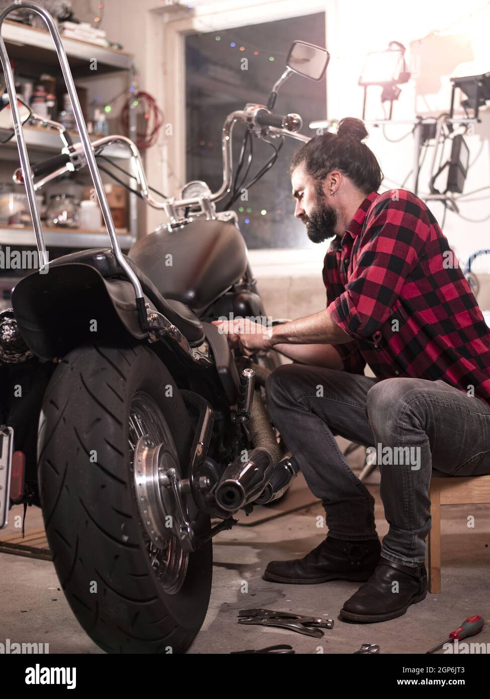 Vertical shot of a German male repairing his motorcycle. Stock Photo