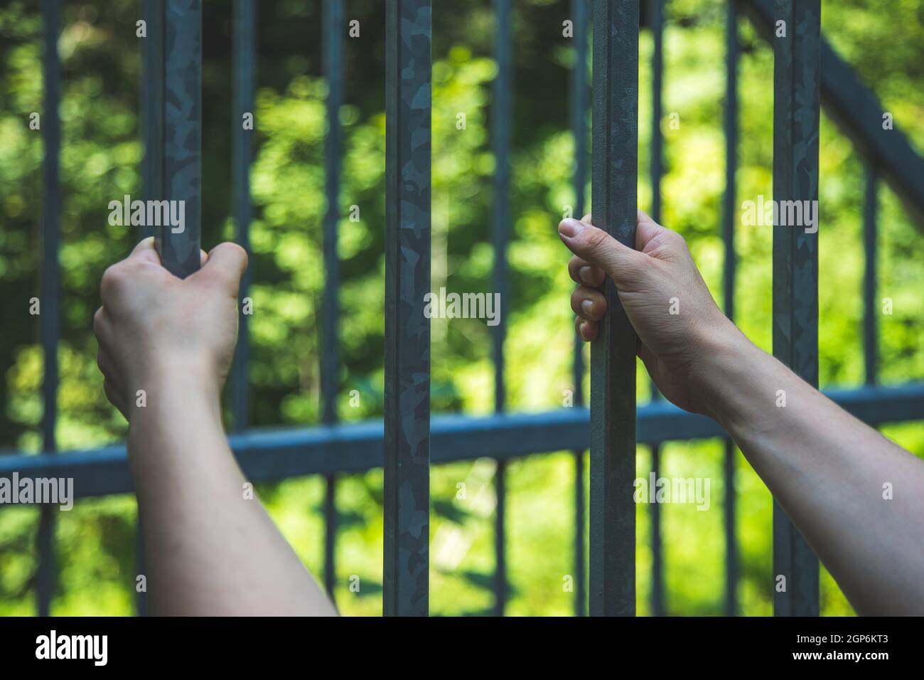 Close up of hands in a prison cell, jail Stock Photo