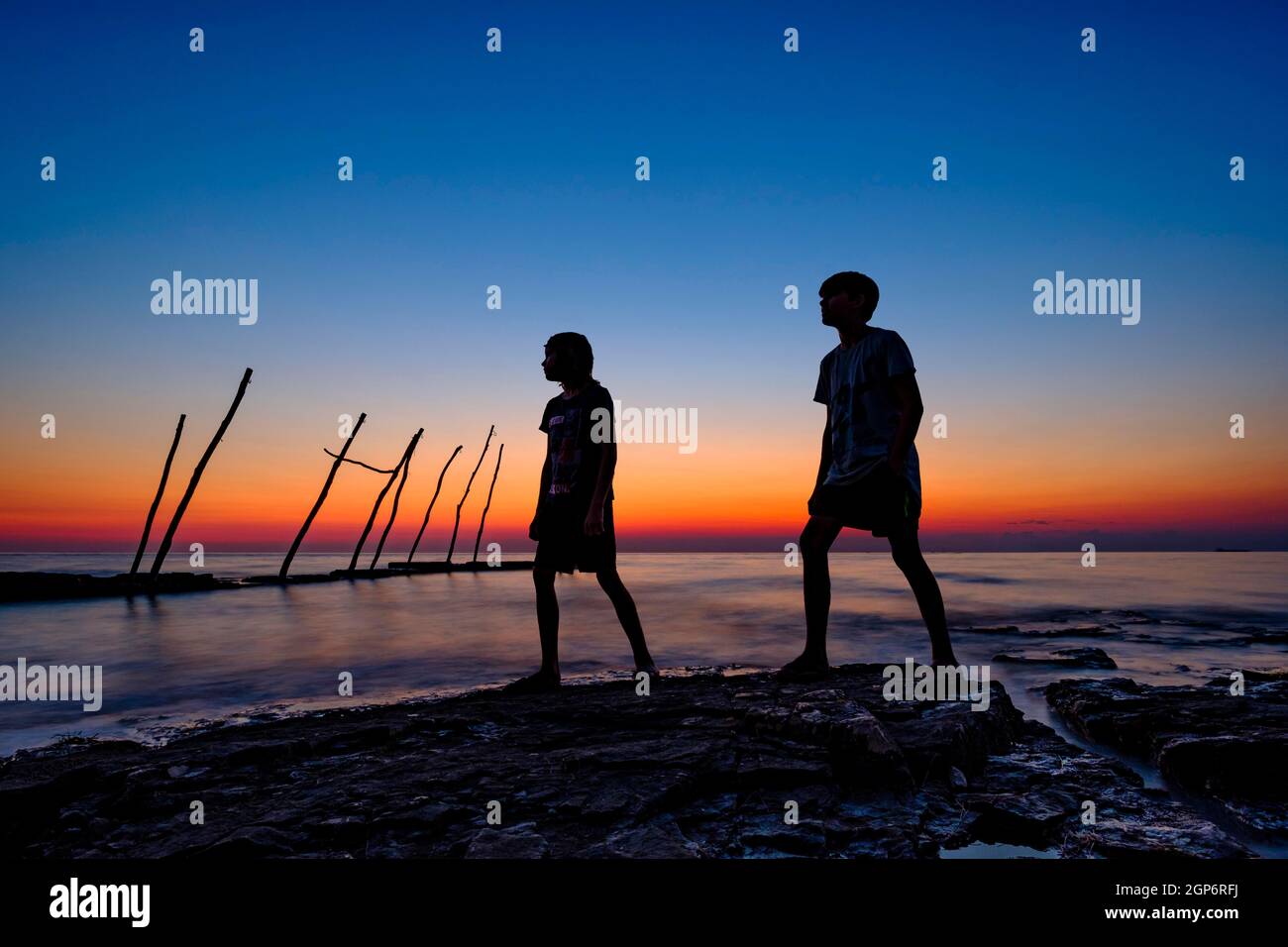 Silhouette of 2 boys by the sea, dusk, Savudrija, Adriatic Sea, Istria, Croatia Stock Photo