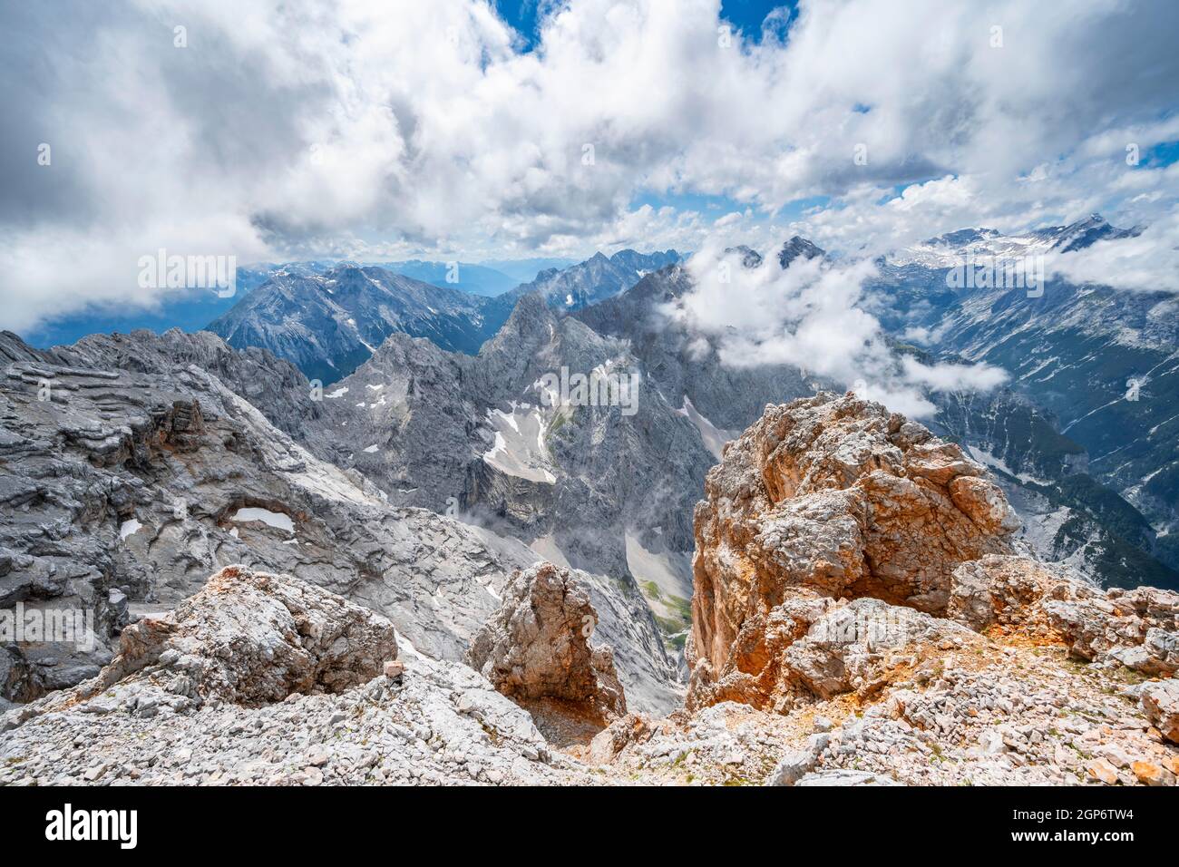 At the summit of the Partenkirchner Dreitorspitze, view into the Reintal valley towards cloud-covered peaks, mountain panorama with ridge of the Stock Photo