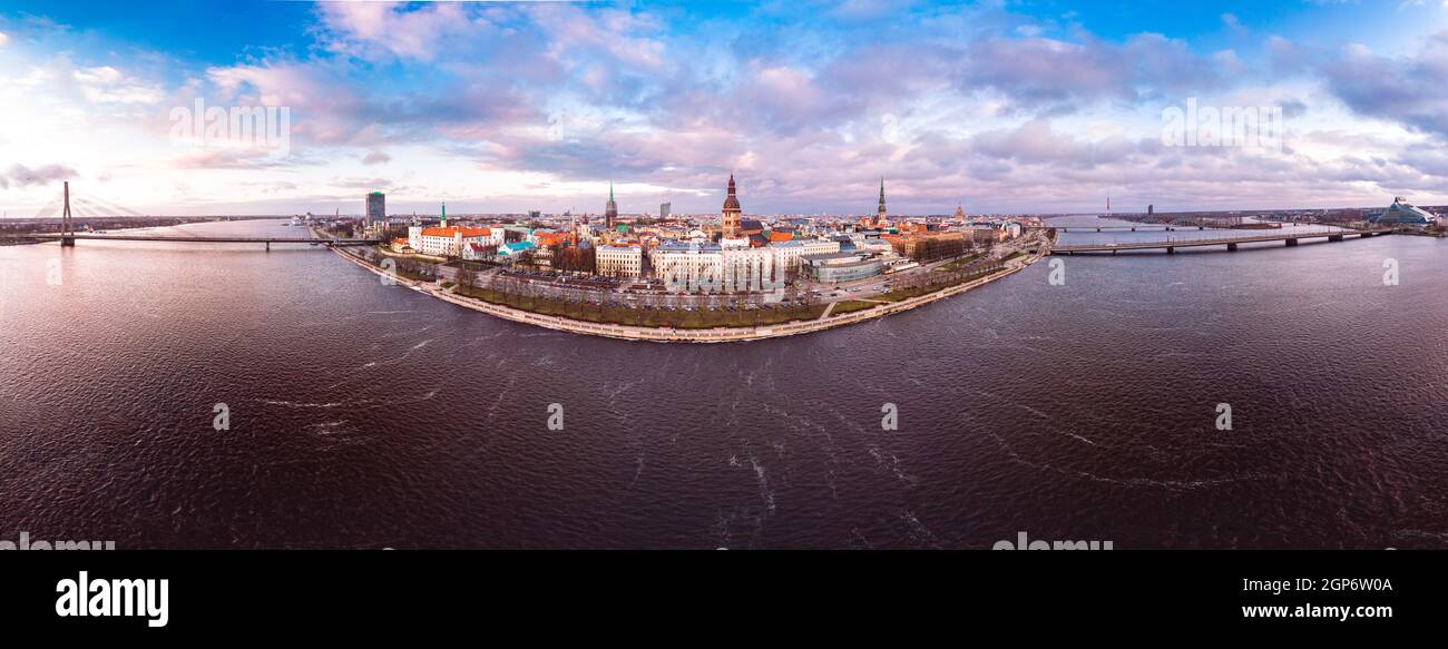 Beautiful aerial panoramic view from old town at sunset near river Daugava, TV tower, embankment and bridge. Riga cityscape in clouds autumn day. Famo Stock Photo