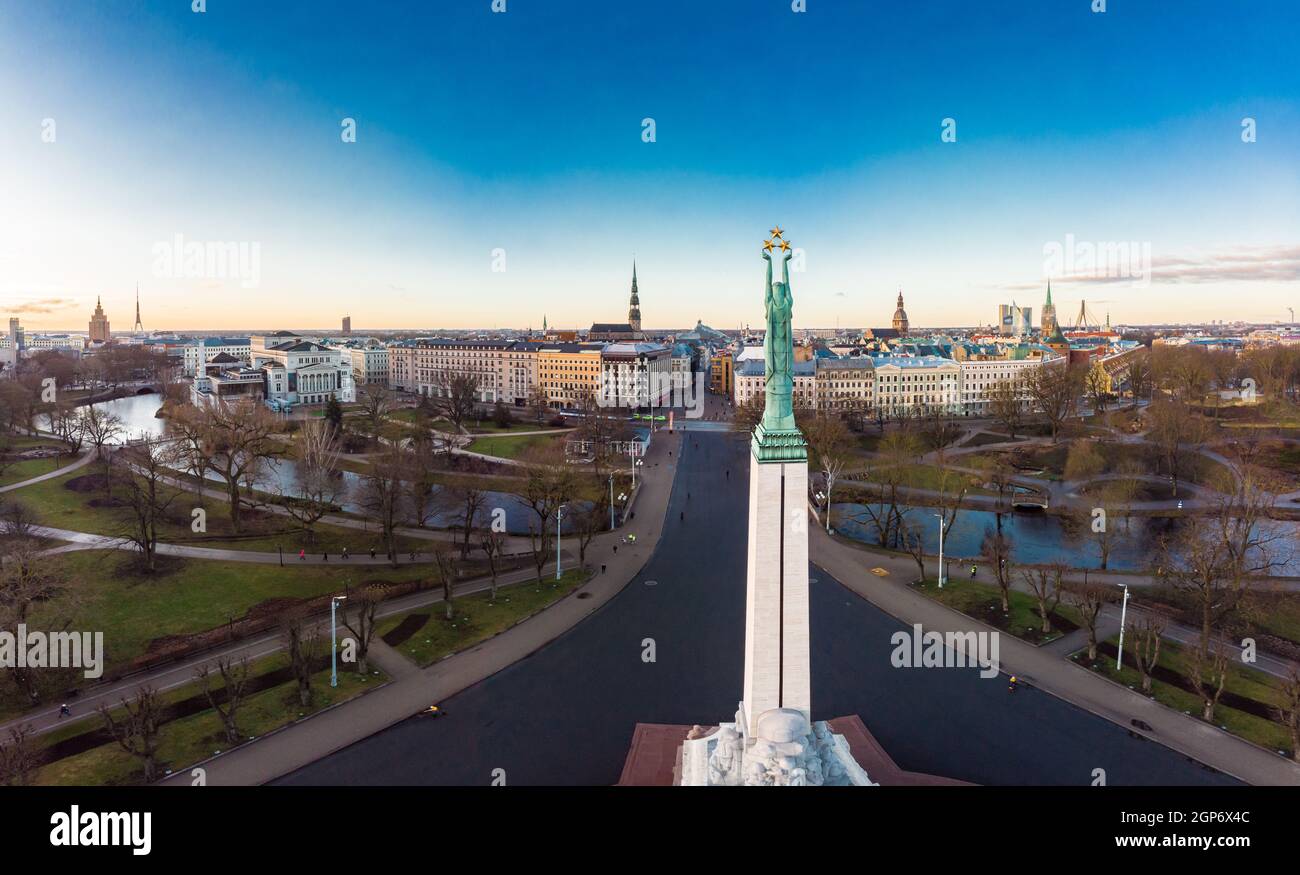 Amazing Aerial panoramic view to Monument of freedom with old town in background, during autumn sunrise. Milda - Statue of liberty holding three Golde Stock Photo