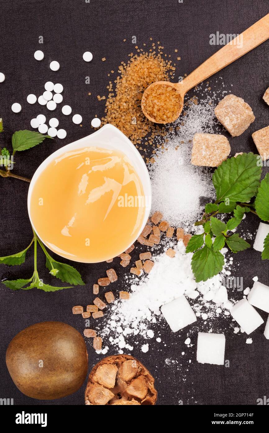 Monk fruit, honey and various types of sugar - brown, white, crystal, cane, powdered and artificial sweeteners from above. Stock Photo