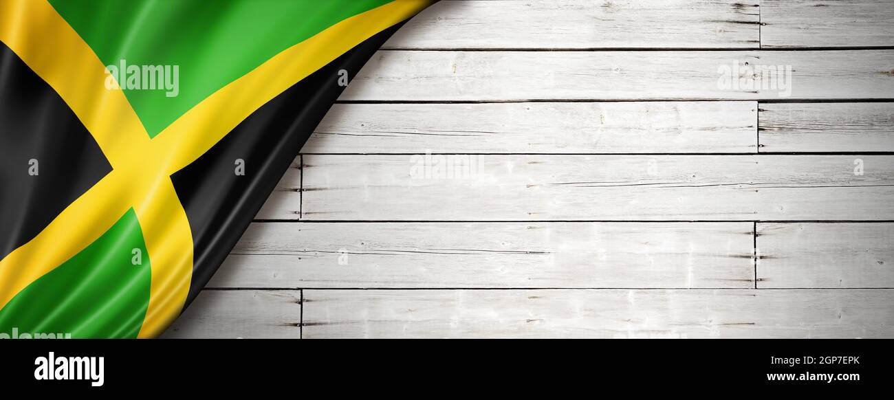 Jamaica flag on old white wall. Horizontal panoramic banner. Stock Photo