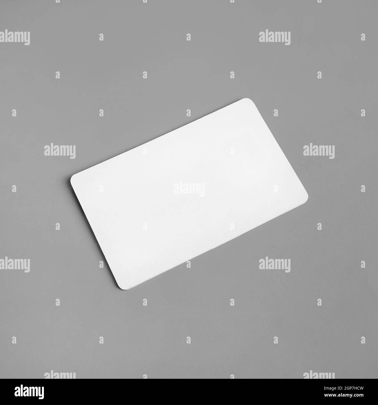 Photo of blank white business card on gray paper background. Branding ID template. Stock Photo