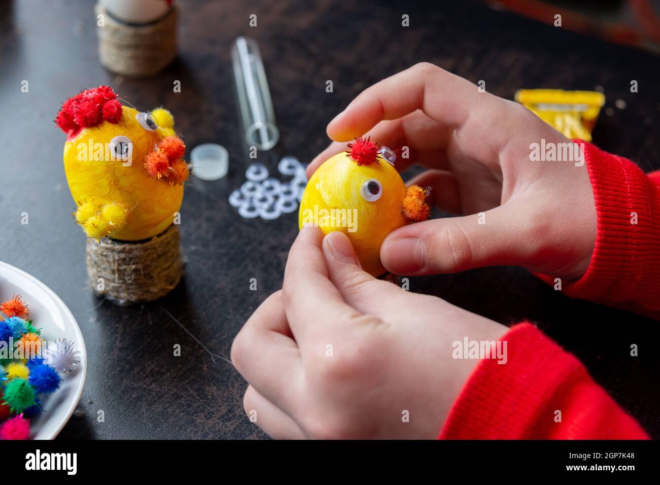 Children's hands make a craft from an egg for the Easter holiday Stock Photo