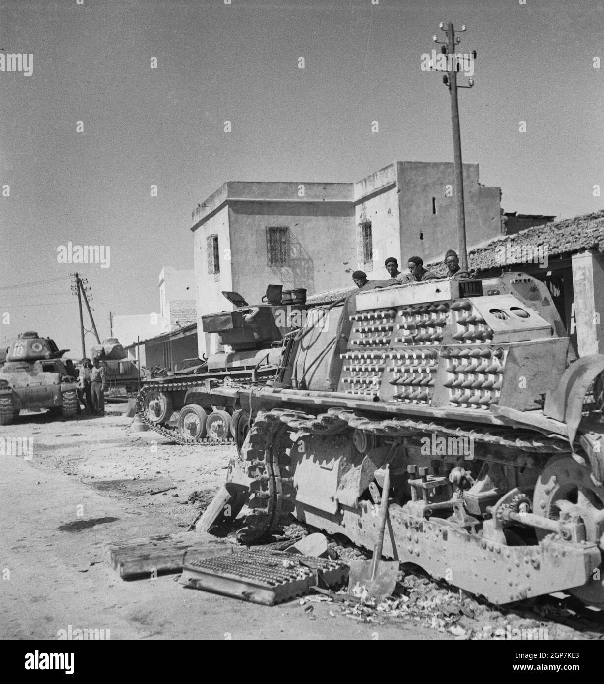 Allied soldiers inspect the wreckage of one of the tanks of the German Tenth and Fifteenth Panzer Divisions. Photo made at Porto Farina where the Nazis were trapped, May 1943 Stock Photo