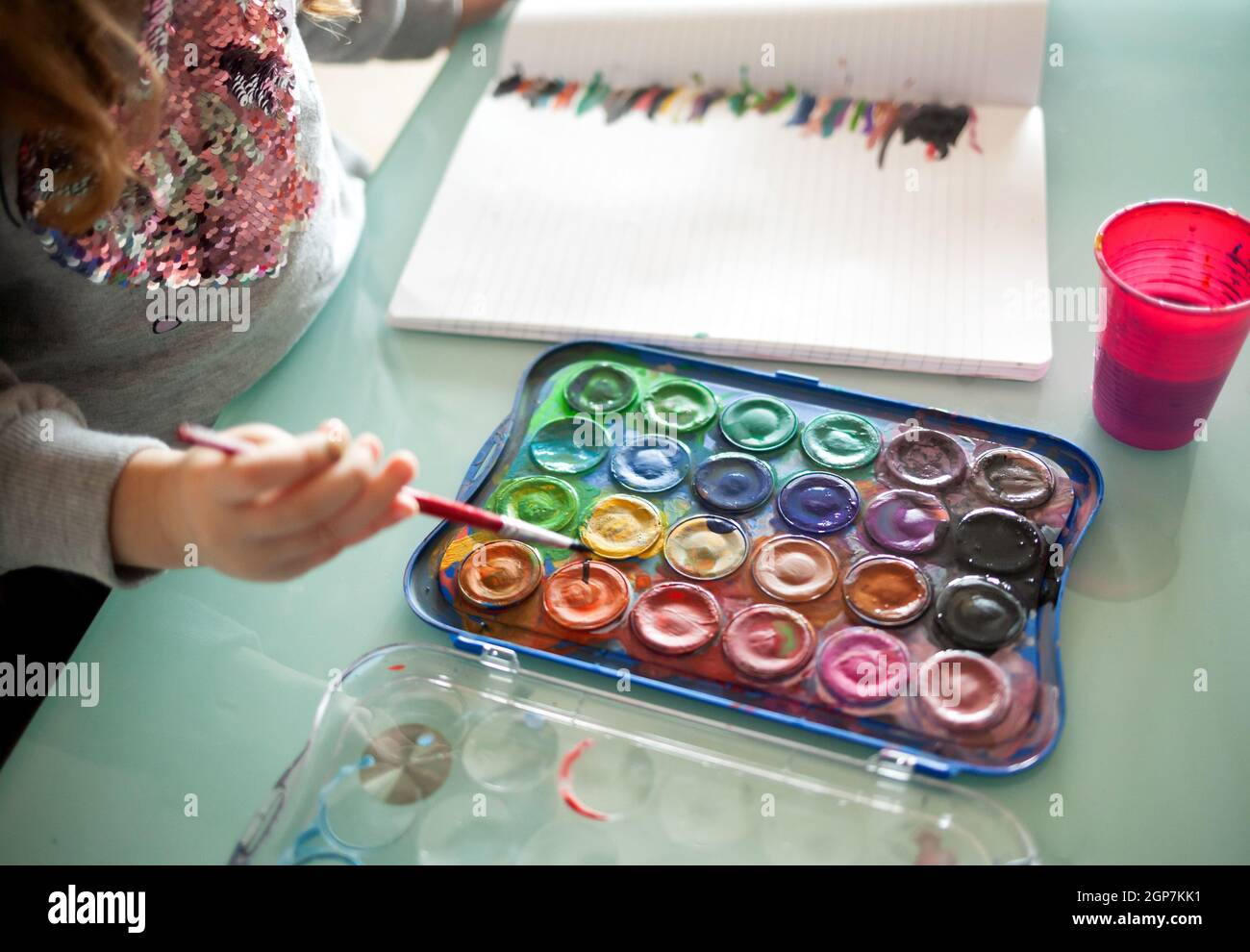Hands of little girl painting with watercolors at home. Learn ...
